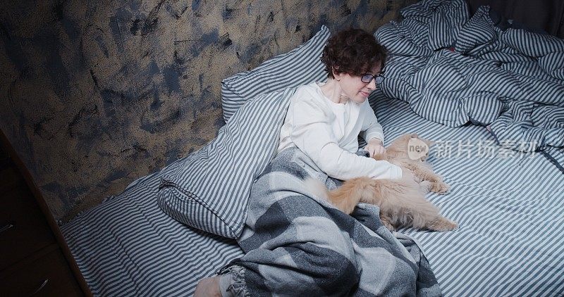 成熟的女人在床上抚摸着毛茸茸的小猫