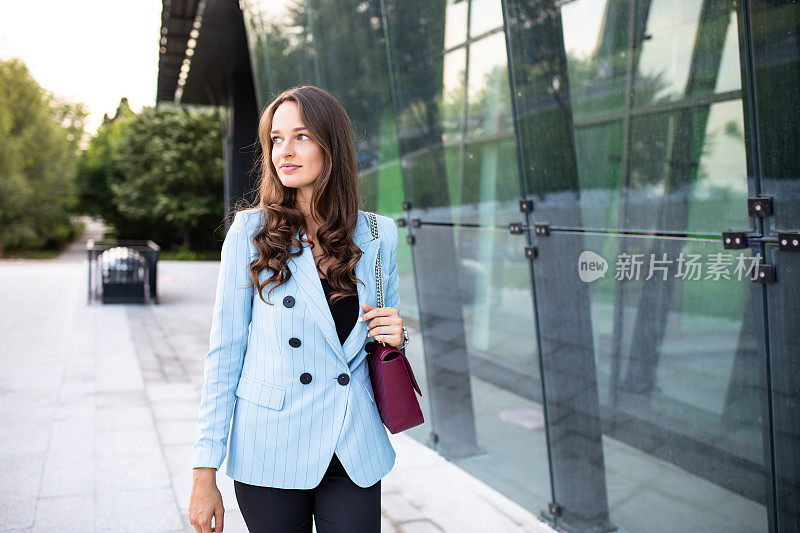 一位女商人正走过一座办公楼