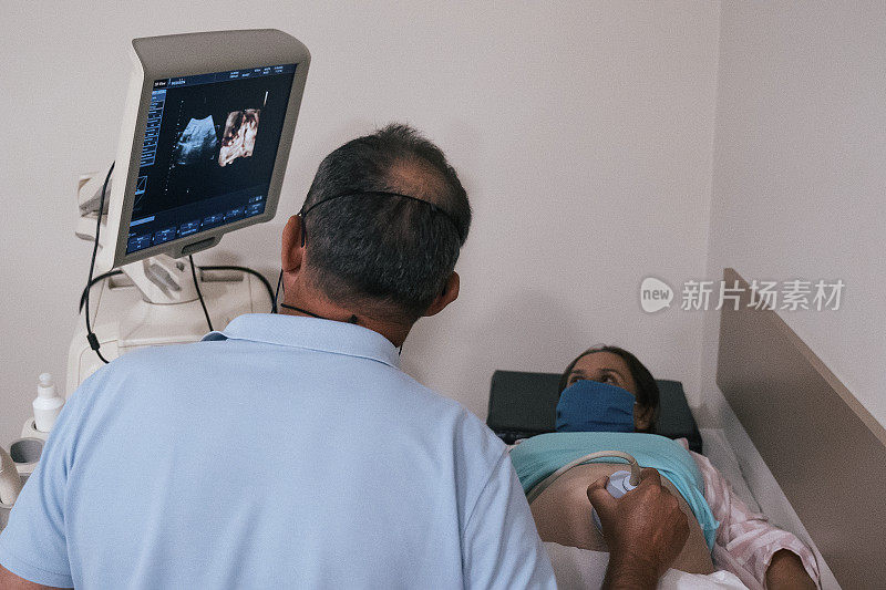 在COVID-19期间怀孕。子宫内胎儿的超声波扫描。在怀孕期间为胎儿做超声检查。2019冠状病毒病期间的体检。