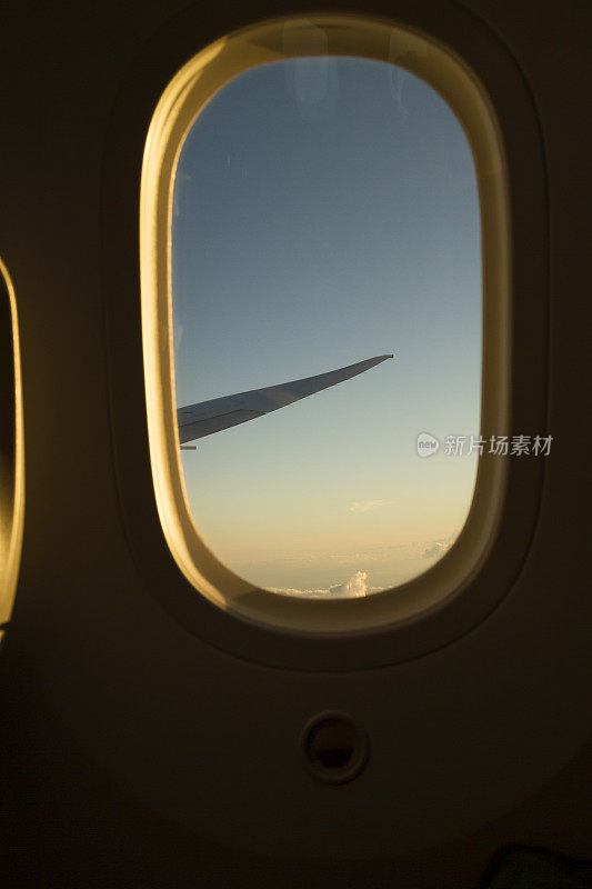 从机场起飞后从舷窗飞机经济舱鸟瞰日出天空。