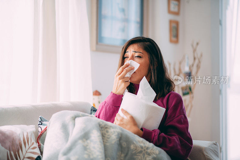 在客厅里用纸巾打喷嚏的女人