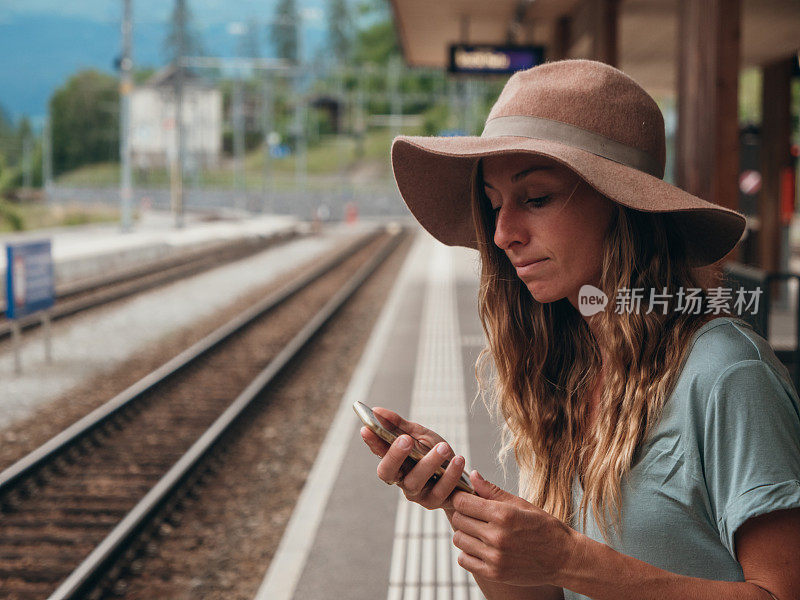 一个女人在火车站检查手机