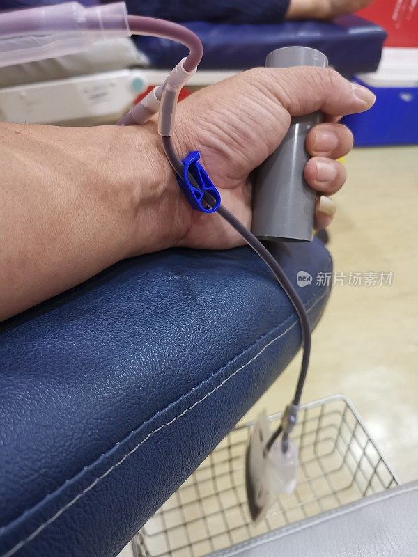 智能手机摄像头拍摄到的亚洲华人紧握献血手的景象