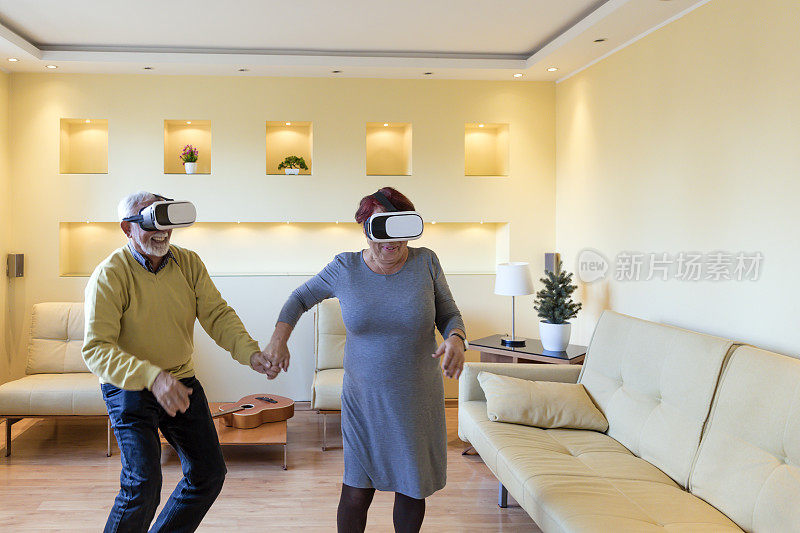 快乐的老人和他的妻子正在虚拟现实模拟器上体验视频游戏。