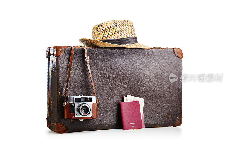 老式的老式棕色皮箱，配有一个胶卷照相机，一顶草帽和两本印有白色机票的护照