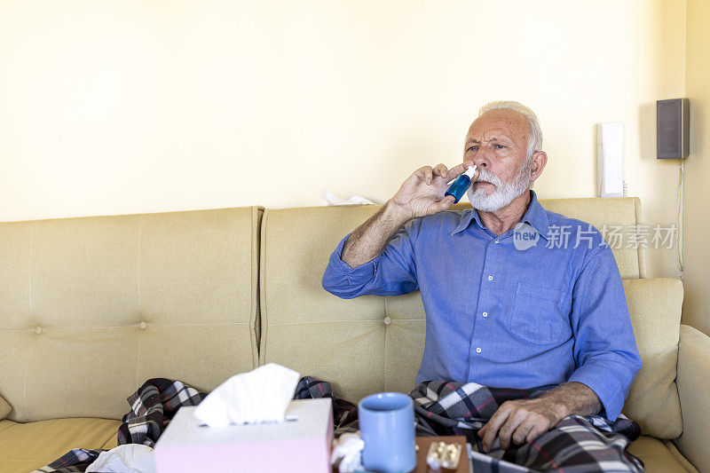 患有季节性流感病毒或鼻窦炎的老人正在使用鼻喷雾剂。