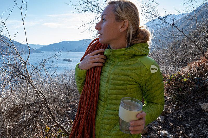 女性攀岩者用可重复使用的旅行杯喝水