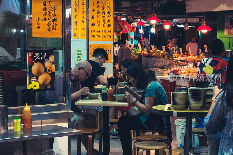 人们晚上在香港的露天街边小吃店吃饭