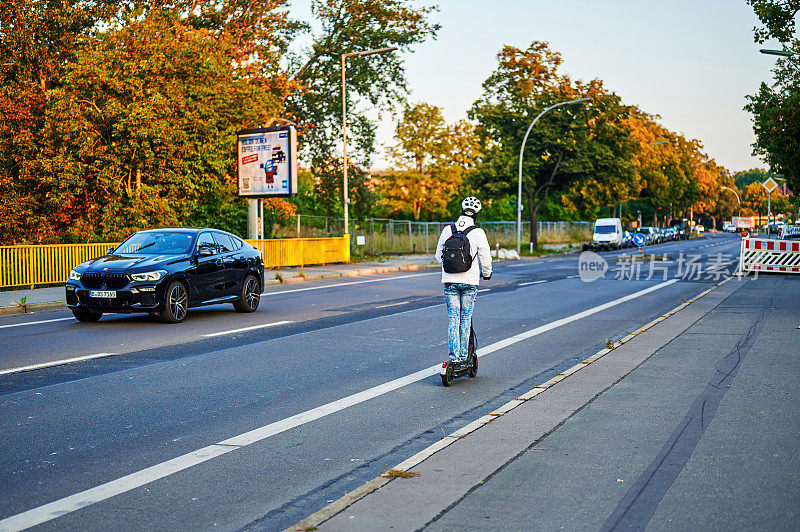 柏林，一个人骑着电动车的街景。