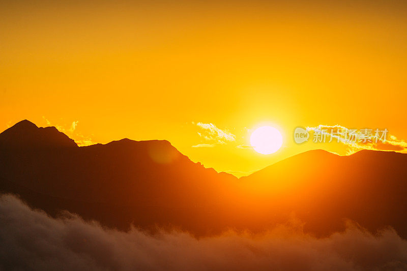 塔特拉山脉和黄色日落的秋景。云朵飘浮于山峰之上