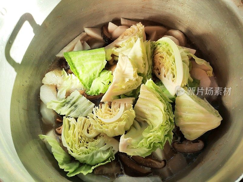 在炉子上的蔬菜炖汤中加入卷心菜-食物准备。