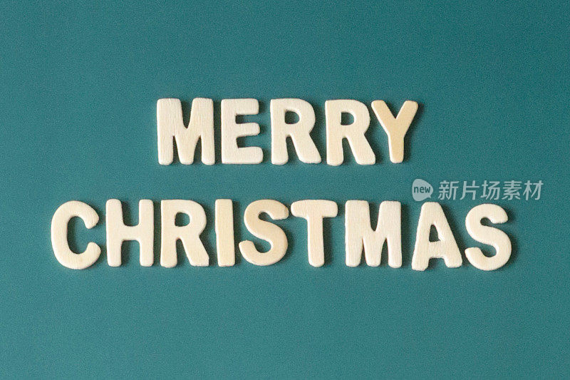 自制DIY简单的圣诞卡设计的图像在青色蓝色背景上剪出白色字母，手工节日圣诞贺卡，圣诞快乐的信息，复制空间