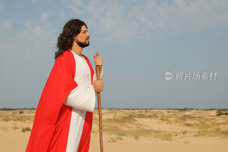 耶稣基督在沙漠中拄着拐杖行走。空间的文本