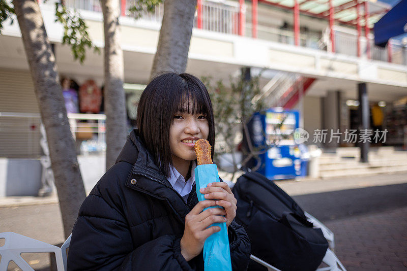 十几岁的女孩在街上吃零食