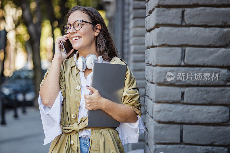 现代年轻女商人在街上讲电话