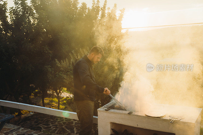 男性在日落的露台上烧烤