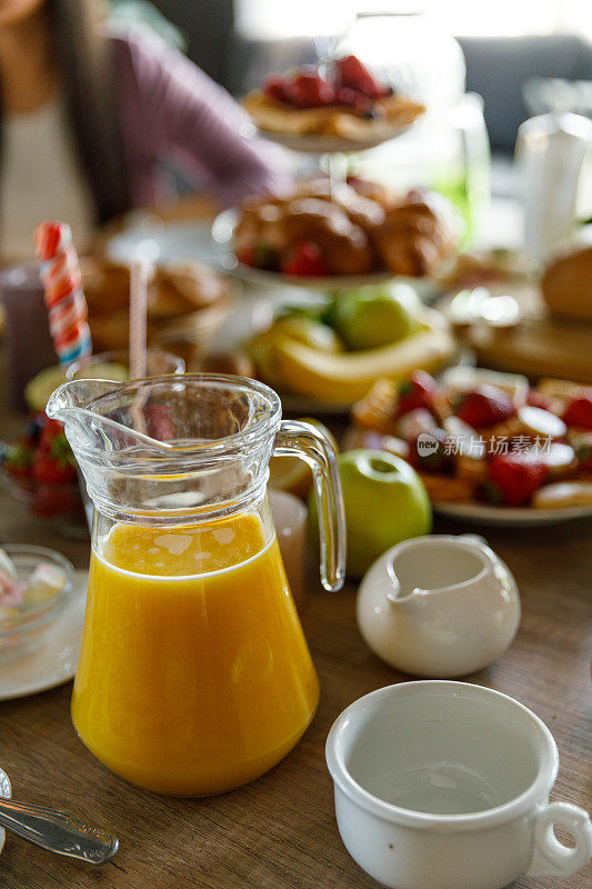 新鲜的橙汁装在玻璃罐里，早餐时放在桌子上