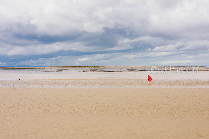 在英国南部的布里斯托尔海峡海岸，低潮时，一处河口的泥滩有下沉的危险，红旗警告人们