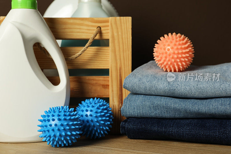 许多干燥球，堆叠干净的衣服和洗衣液在木桌上