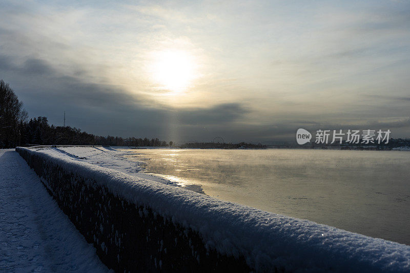 冬天的河堤。河上的黎明。冬河在城中。在一个阳光明媚的大雪冬日，河边的城堤。