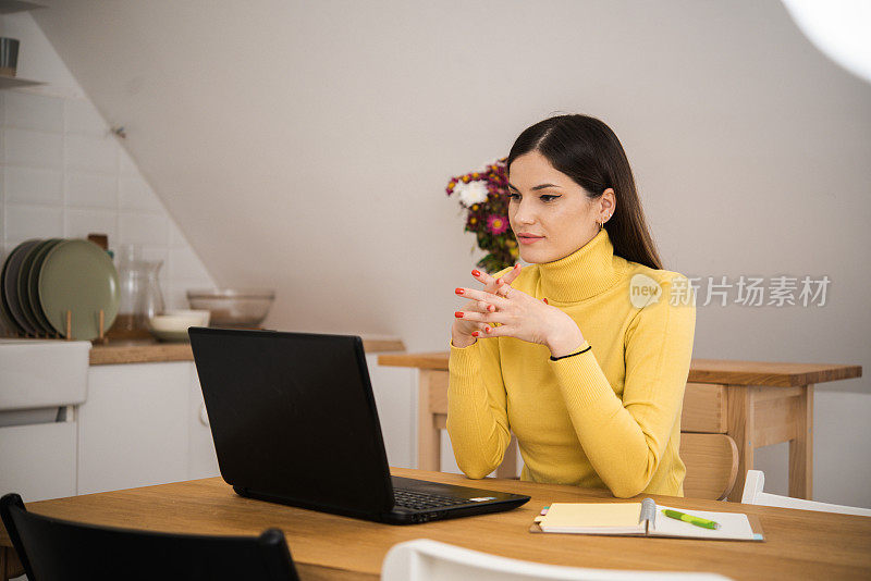 一个快乐的年轻女子在网上工作时享受咖啡的肖像