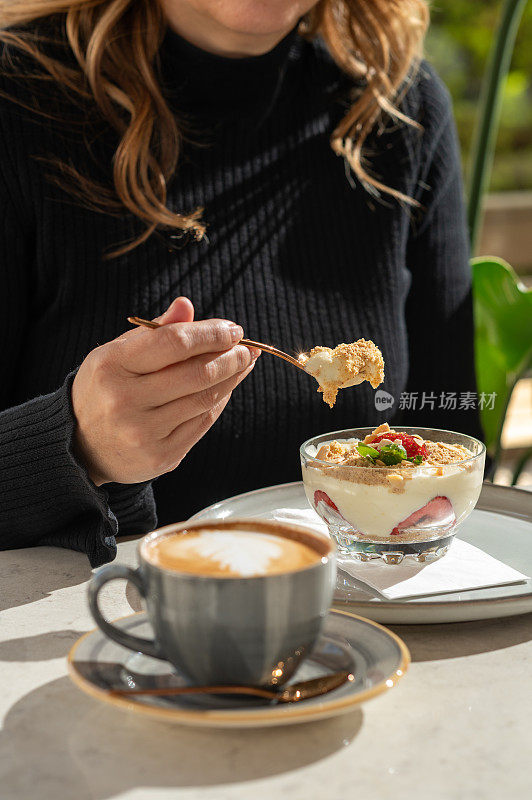 一位年轻女子正在喝一杯咖啡拿铁。