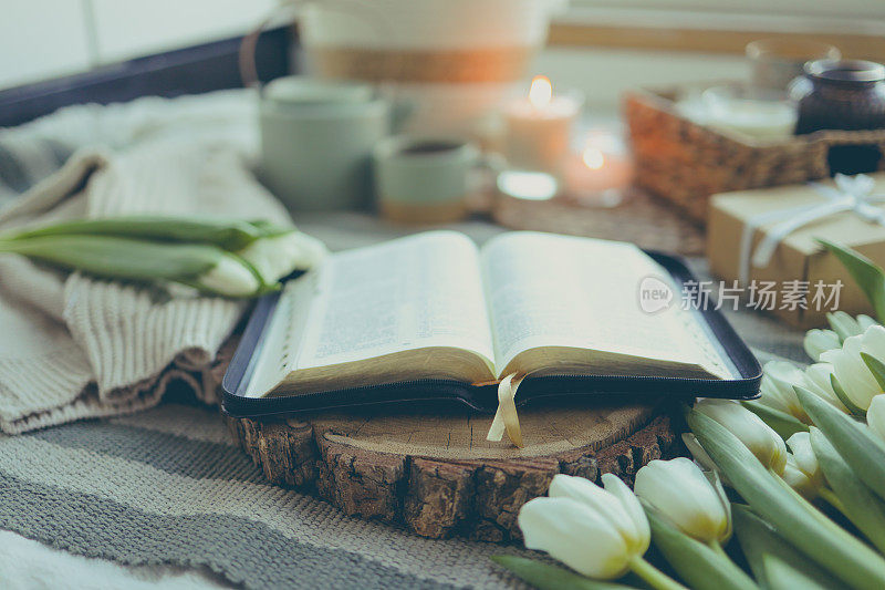 打开圣经在木架与鲜花在家里的内部