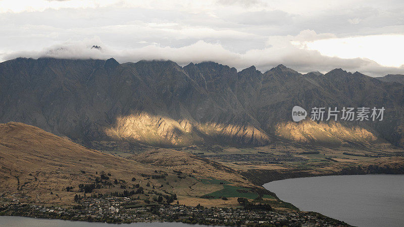 鸟瞰新西兰云层下的岩石悬崖和乡村山谷
