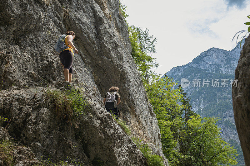 勇敢的旅行者爬上岩石的边缘