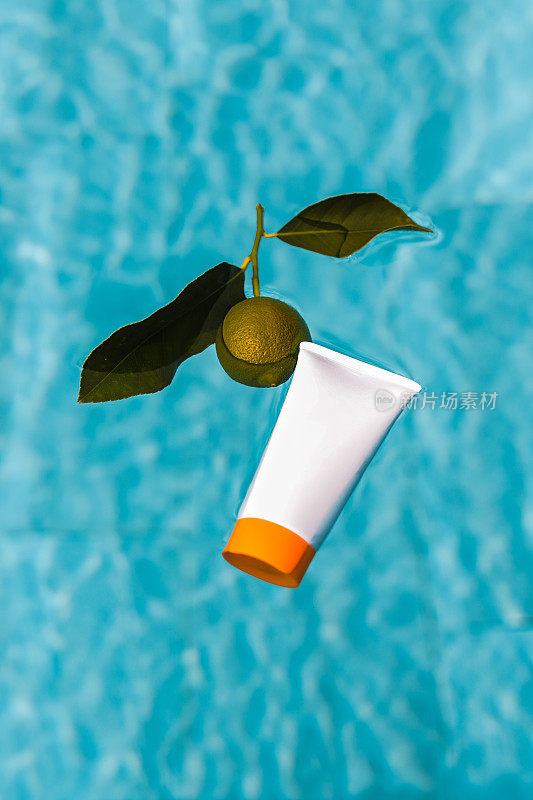 美容产品管包装漂浮在游泳池水面与酸橙水果