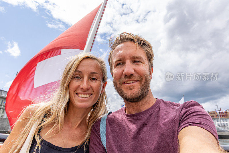 一对夫妇在卢塞恩手持瑞士国旗自拍