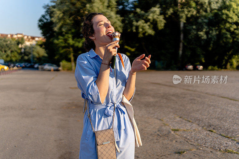 年轻女子在户外吃冰淇淋消暑