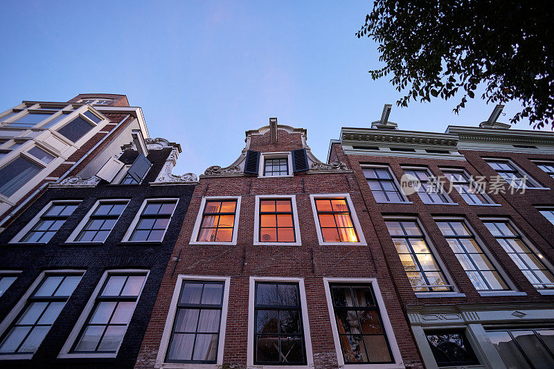 黄昏时分，阿姆斯特丹历史悠久的运河房屋的正面景观