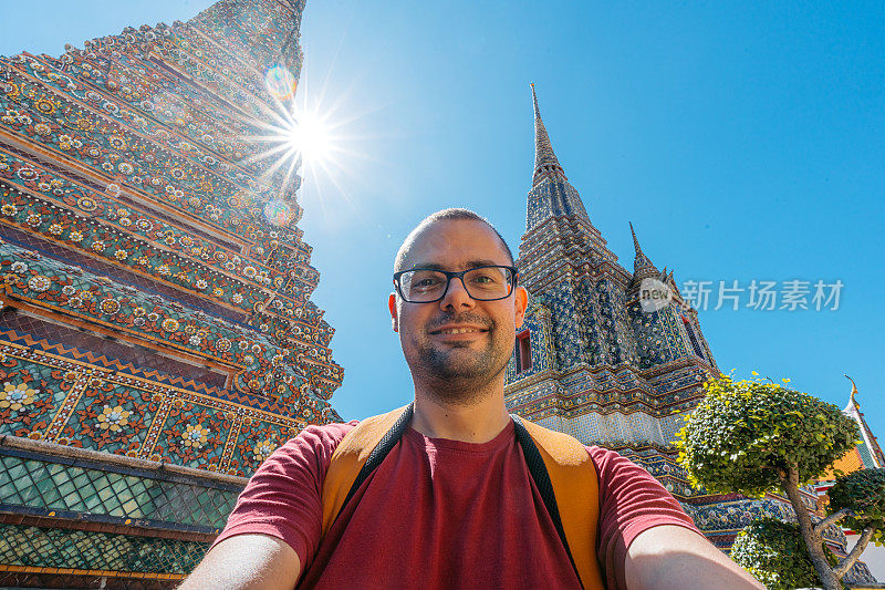 在泰国曼谷卧佛寺自拍的年轻人