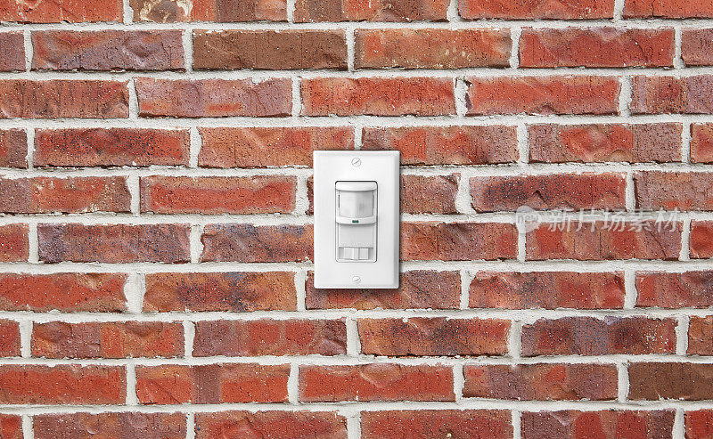 砖墙上的电灯开关传感器和调光器