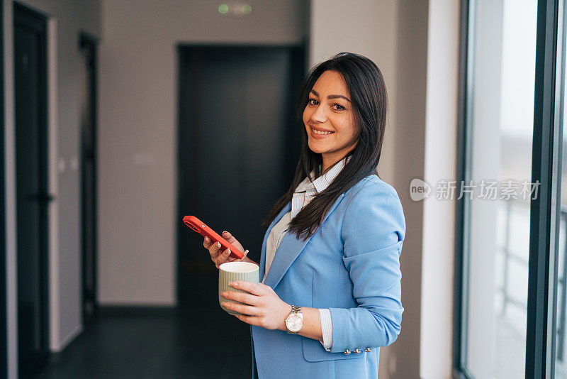 年轻的女商人使用手机和短信