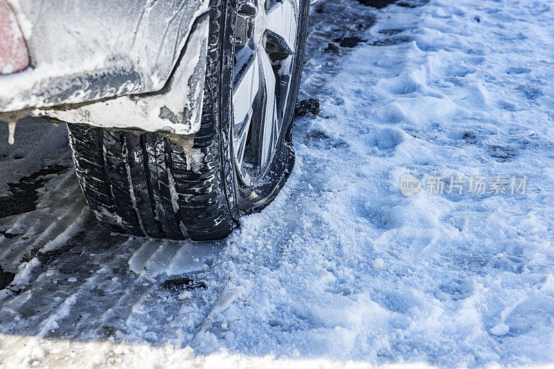 汽车爆胎在潮湿的冬季冰雪上的特写
