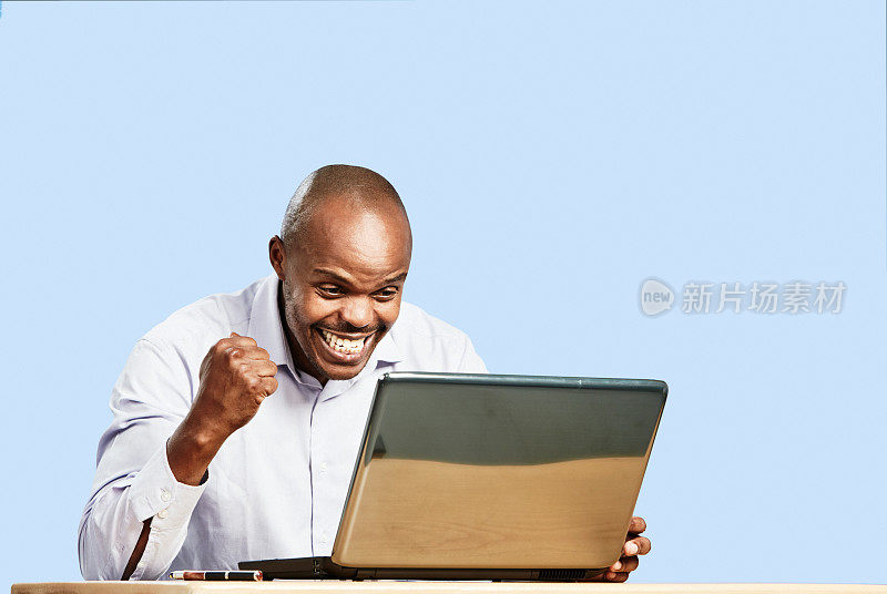 是的!当他在笔记本电脑上得到好消息时，喜出望外的男子笑着捶着空气