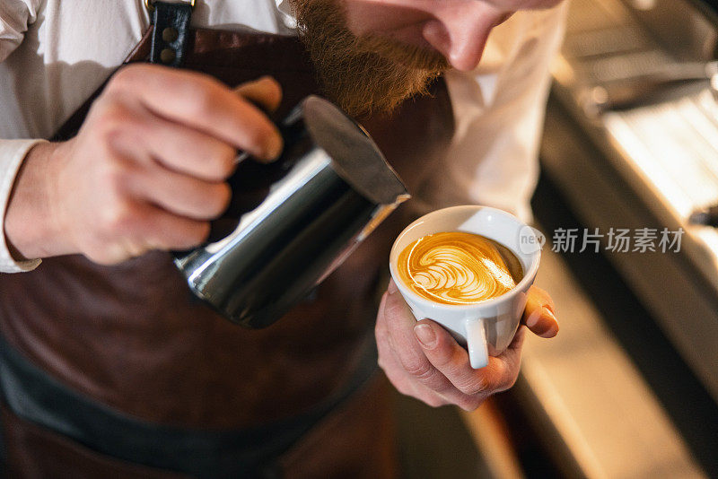 一位才华横溢的白人男咖啡师制作拉花艺术的特写