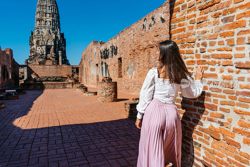 在泰国大城府历史公园的Ratchaburana寺，一位年轻女子的后景