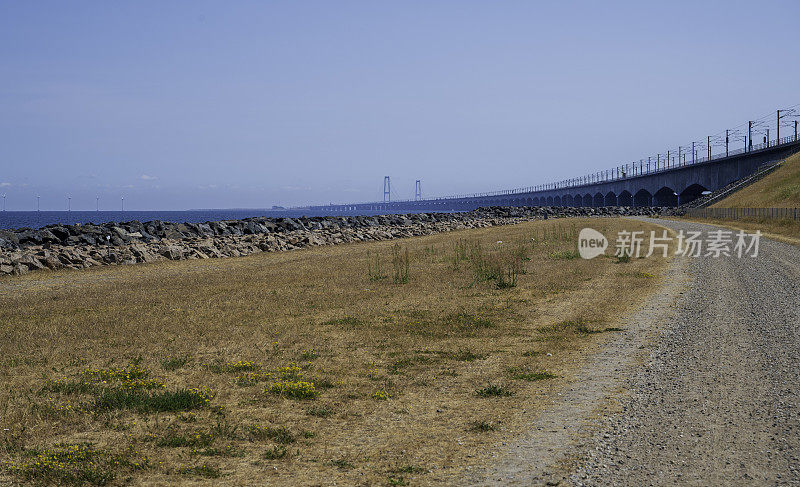 长长的混凝土桥横跨大海，砾石道路和岩石海岸