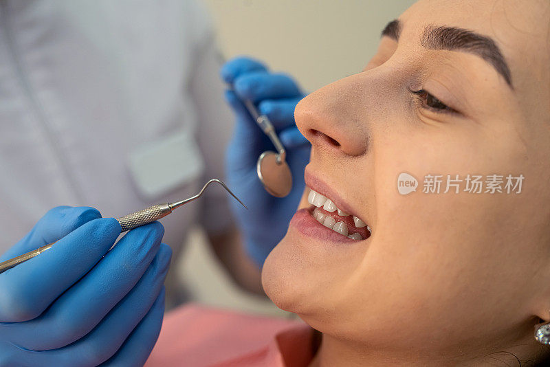 牙医在牙科诊所为女病人进行全面检查