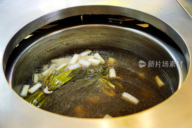 泰国一家街头小吃店的汤面，在沸腾的锅中加入香料调味的汤。