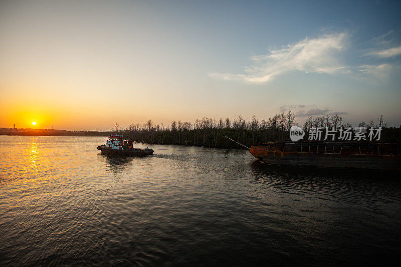 印度尼西亚东加里曼丹，一艘载着煤炭驳船的船经过巴里巴潘湾的卡里安高港附近。东加里曼丹省以煤矿生产而闻名。