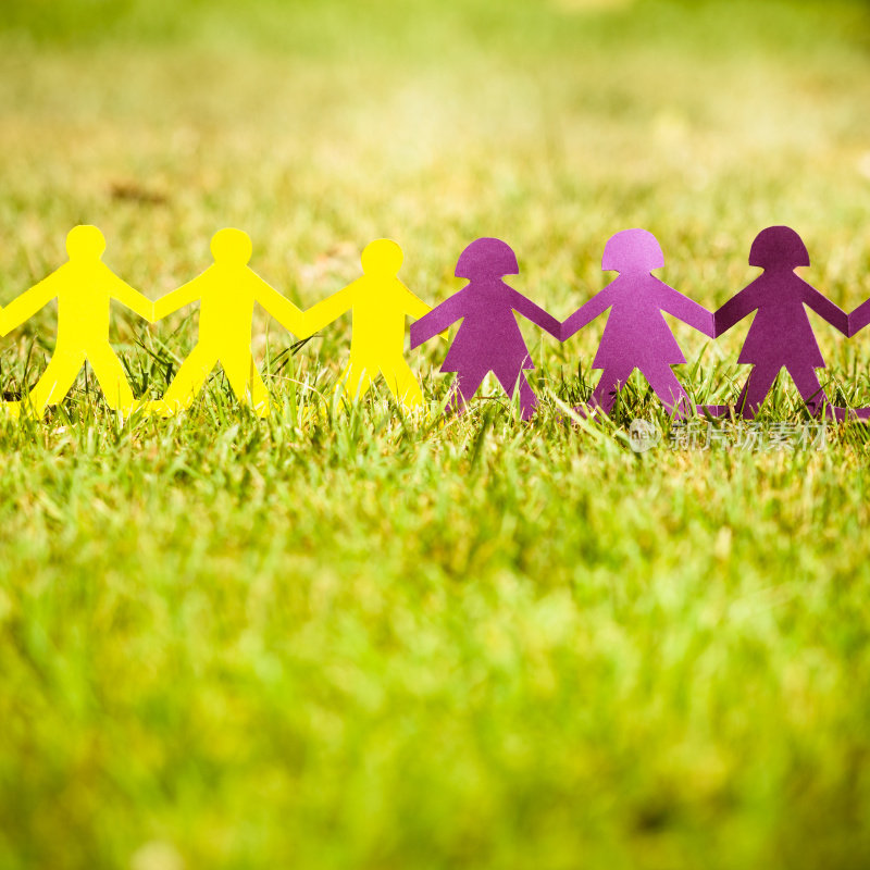 纸娃娃在草地上像一个社区-团队合作