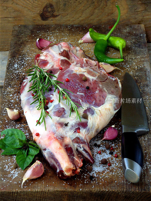 新鲜的生肉。放上香料的羊腿放在木板上，用刀烤，炖，烧烤，
