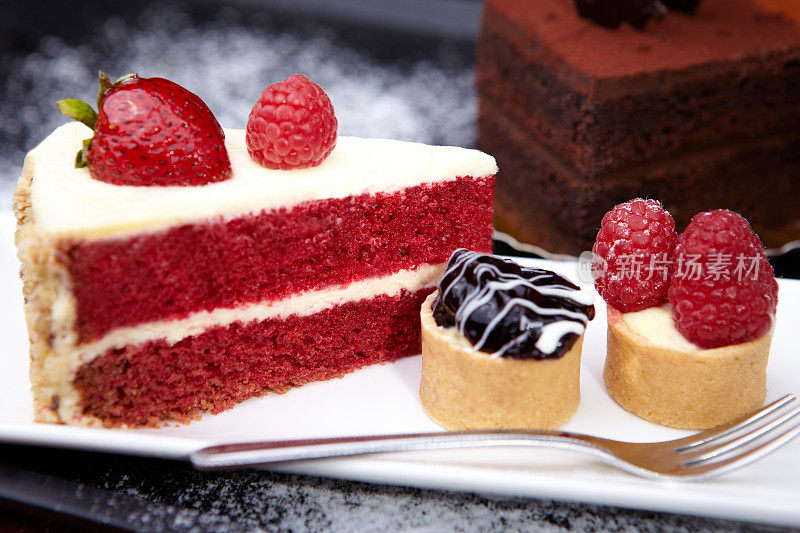 白盘子上的草莓蛋糕、纸杯蛋糕和巧克力蛋糕
