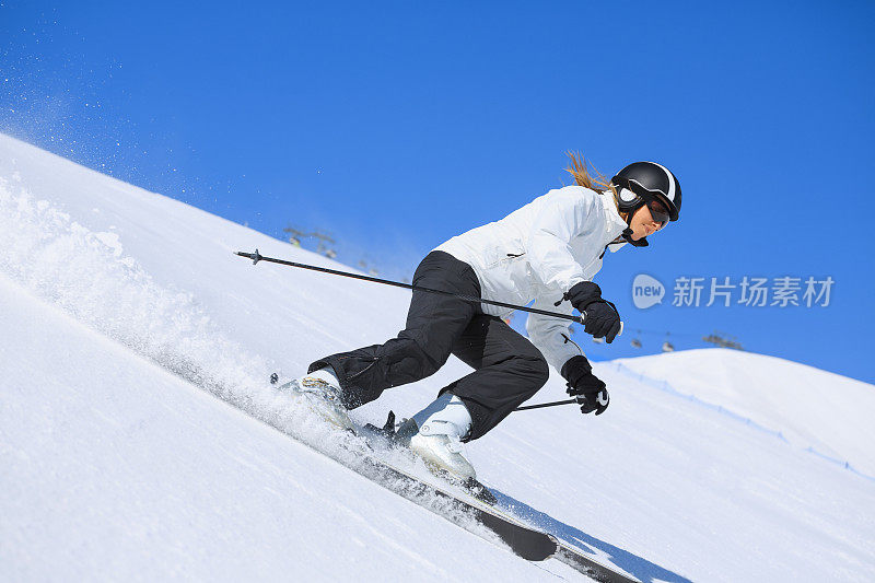 在阳光明媚的滑雪胜地滑雪的中年妇女滑雪