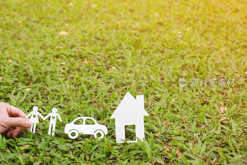 剪纸家庭与房子和汽车在绿色草地上