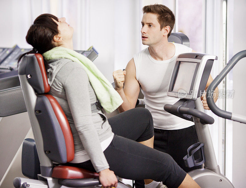 年轻的胖女人在健身房锻炼。